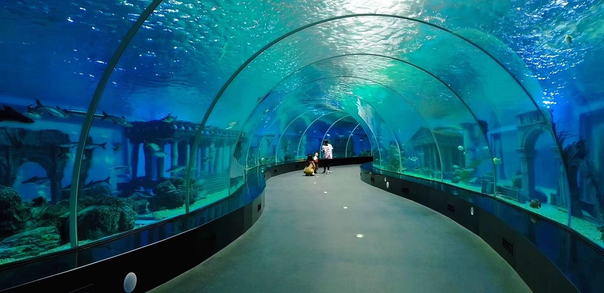Why do aquarium underwater tunnels prefer to use acrylic instead of glass